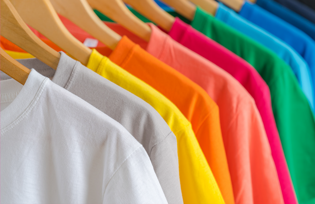Coloured T shirts hanging on clothes rack